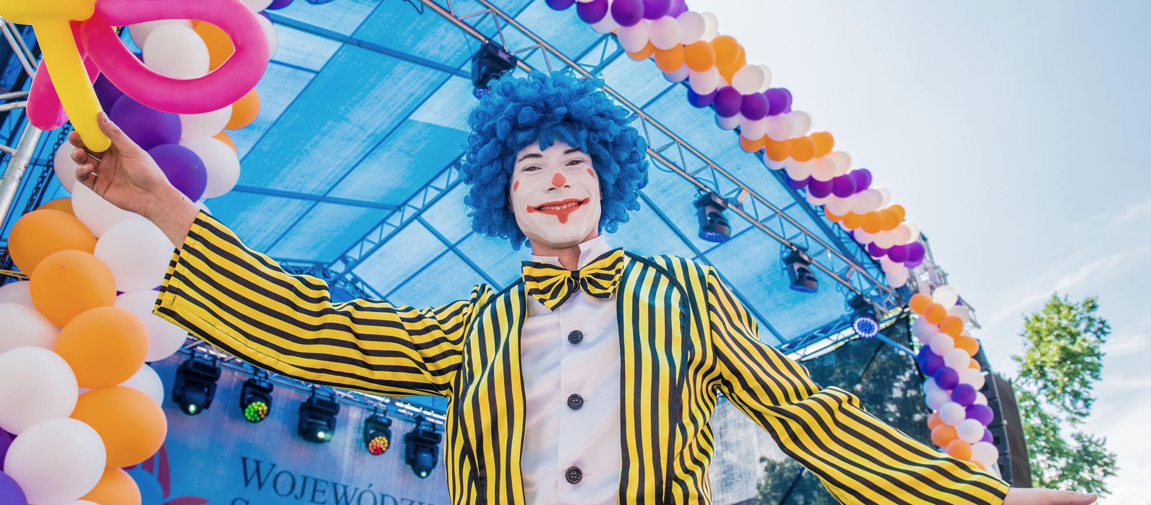 Uśmiechnięty animator w przebraniu clowna podczas uroczystości zakończenia modernizacji szpitala