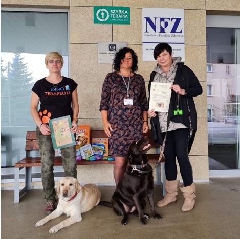 Trzy osoby z psami terapeutycznymi.