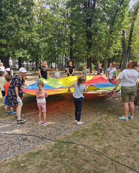 Pacjenci i wolontariusze Stowarzyszenia Uśmiech Nadziei Dzieciom podczas wspólnej zabawy w parku