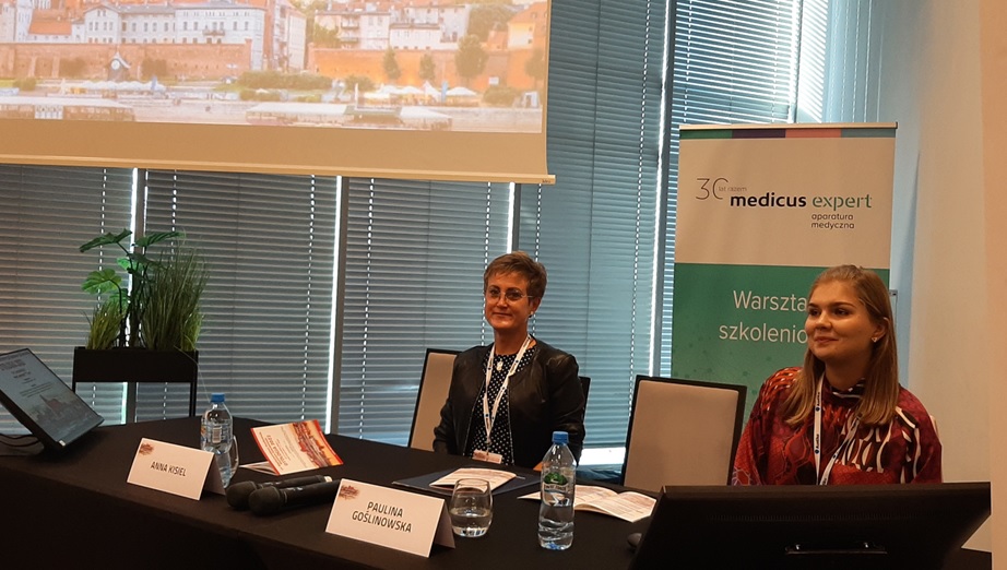 Prezentacja podczas warsztatów szkoleniowych organizowanych przez Medicus Expert, uczestnicy przy stole.