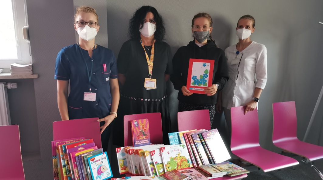 Personel szpitala z uczennicą liceum i przekazanymi na rzecz pacjentów książkami
