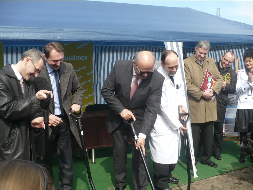 Uczestnicy ceremonii rozpoczęcia budowy, trzymając łopaty.