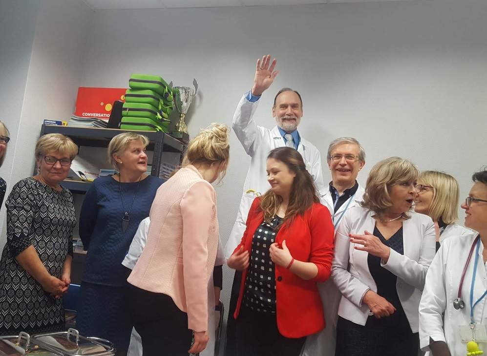 Zespół medyczny w białych kitlach świętuje sukces w przyjaznej atmosferze.