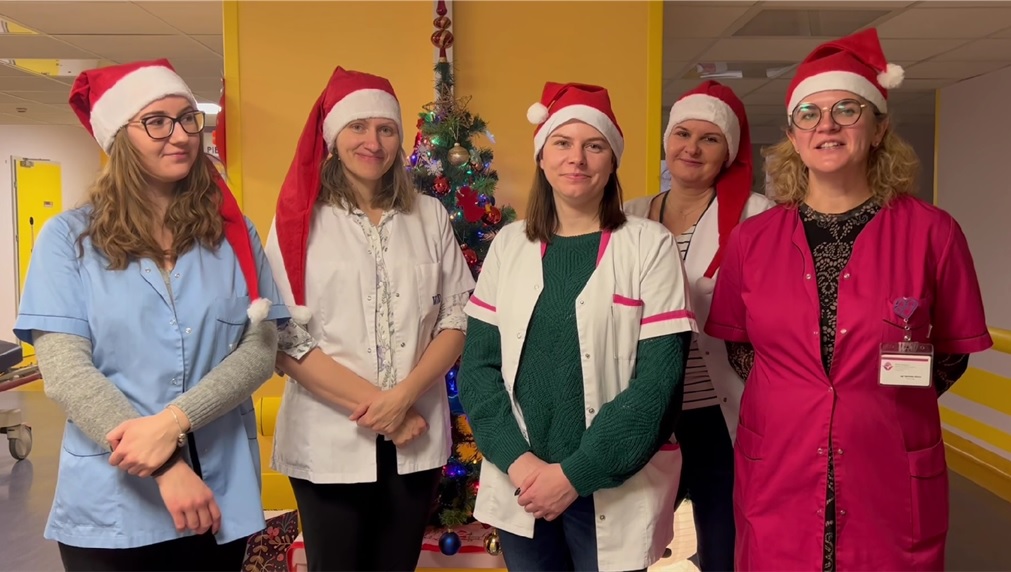 Zespół Psychologów Wojewódzkiego Szpitala Dziecięcego w Bydgoszczy w czapkach świętych Mikołajów składa życzenia świąteczne w Oddziale Pneumonologii
