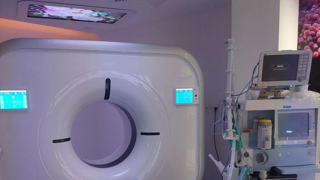 Nowoczesne urządzenie tomografii komputerowej Philips w szpitalnej sali, monitor i aparatura medyczna w tle.